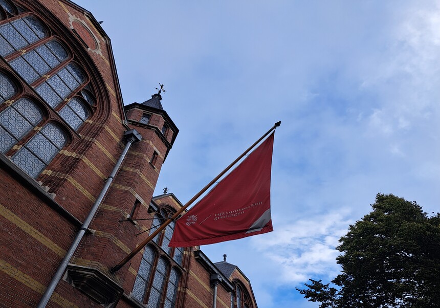 Bandera onejant amb el logotip i el nom de la Universitat de Groningen en neerlandès.